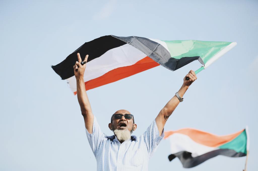 Homme qui brandit un drapeau du Soudan