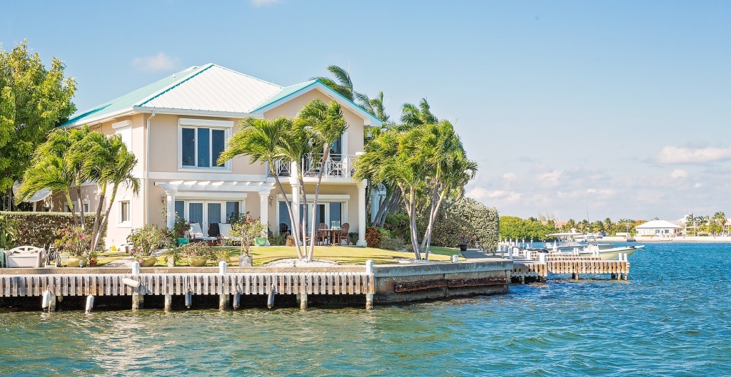 Maison beige avec un toit bleu turquoise au bord de l'eau