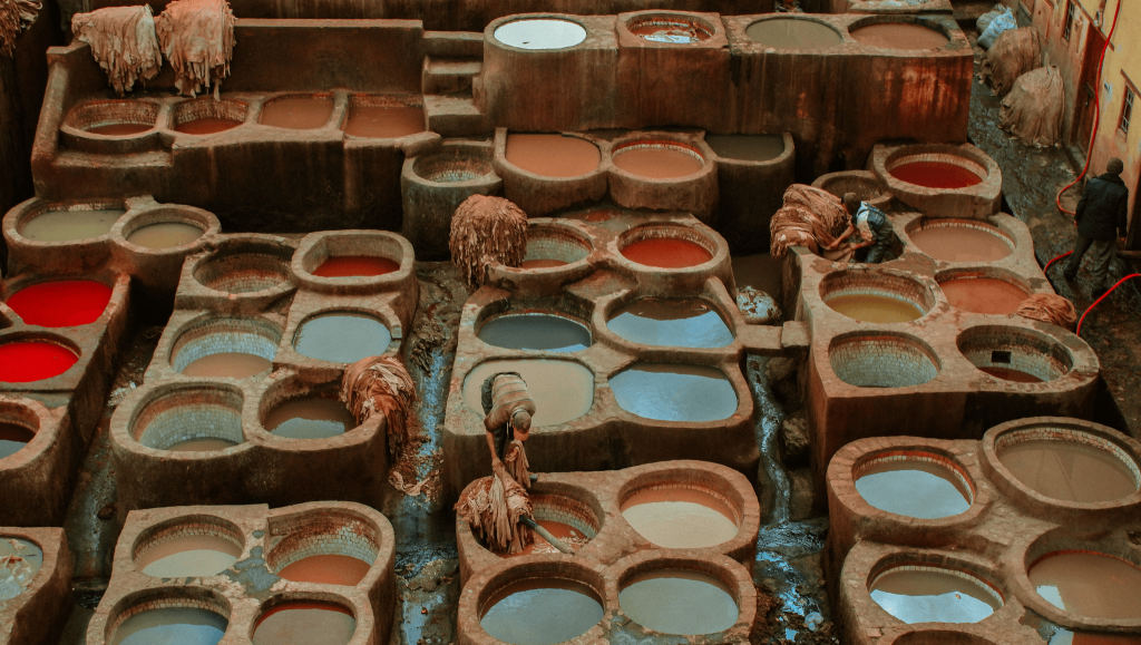 Travailleurs et teinture en peaux rouges dans les cuves des tanneries de Fès au Maroc